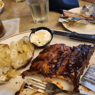 a plate of ribs and potatoes