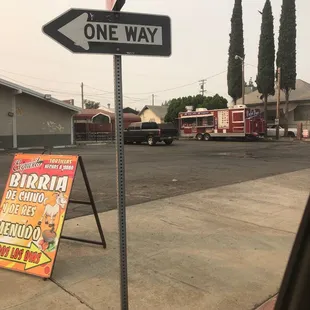 a one way sign on a sidewalk