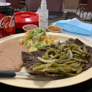 Carne Asada with cactus and onions on top, beans guacamole hand sanitizer and mask lol