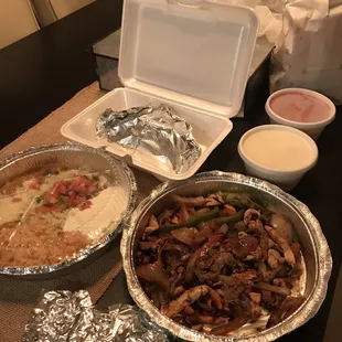 Chicken &amp; steak fajitas, sides of rice &amp; beans, pico de gallo, cheese dip, salsa, side of tacos.