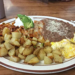 a plate of food with eggs, potatoes, and beans