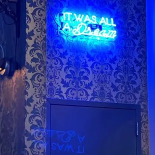 a man standing in front of a neon sign