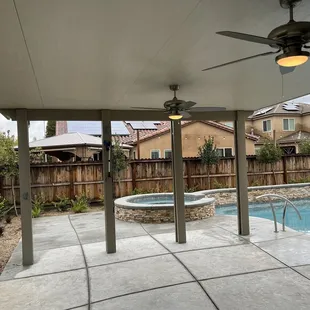 a pool and patio with a ceiling fan
