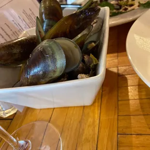 a bowl of mussels and a glass of wine