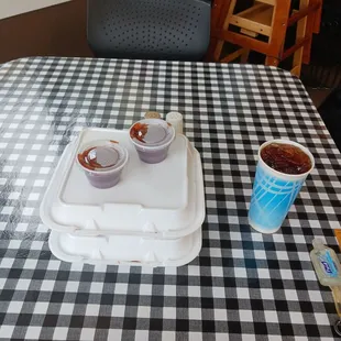 a tray of ketchup and two cups of ketchup on a table