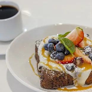 a plate of french toast topped with berries and powdered sugar