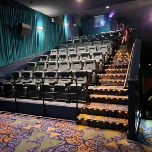Looking up at the comfortable seats, and someone cleaning after the movie