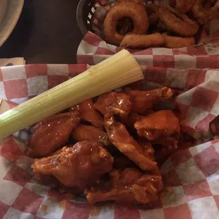 a basket of chicken wings and onion rings