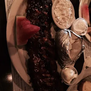 Dinner bbq baby back ribs with baked potato and coleslaw.