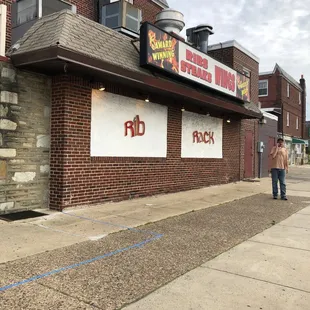 a man standing in front of a restaurant