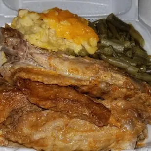 chicken, mashed potatoes, and green beans in a styrofoam container