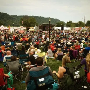 a large crowd of people sitting in lawn chairs