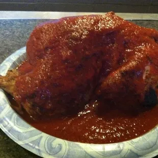 a whole chicken covered in marinara sauce