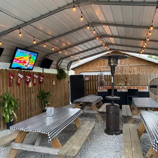 a patio with a grill and picnic tables