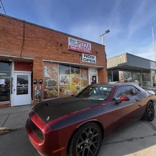 a red sports car parked in front of a restaurant
