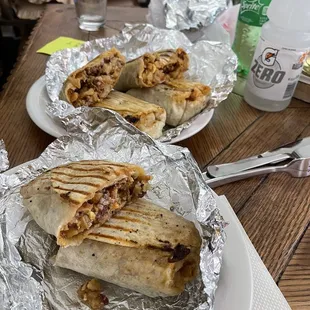 two plates of burritos on a table