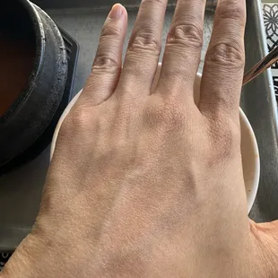 a person&apos;s hand holding a spoon over a bowl of soup