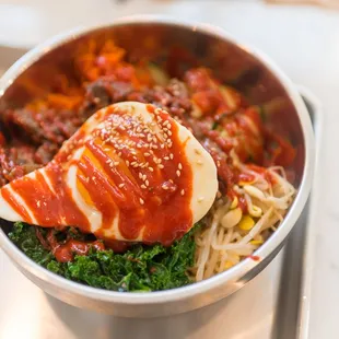 a bowl of food with sauce and vegetables