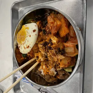 a bowl of food with chopsticks