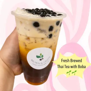 a hand holding a cup of boba