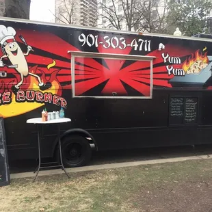 a black food truck with red and black graphics
