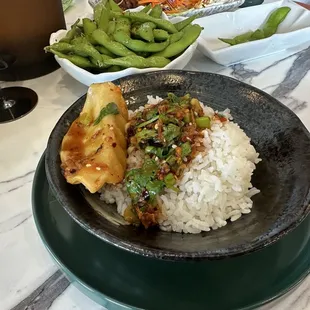The end of a bowl of Szechuan dumplings, poured over a bowl of white rice