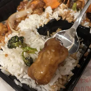 A soggy piece of battered chicken with two tiny sesame seeds on it. No seeds on any other pieces.