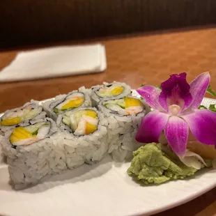 a plate of sushi and a flower