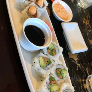 a plate of sushi and dipping sauce