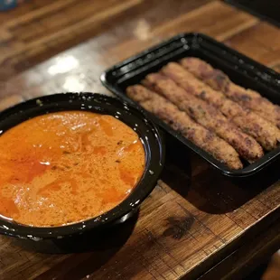 a bowl of soup and a tray of sausages