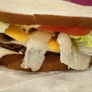 Turkey sandwich with mayonnaise, lettuce, tomato and Colby cheese.