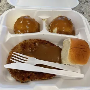 Hamburger steak with mashed potatoes x 2 and a roll.