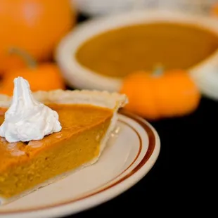 a slice of pumpkin pie with whipped cream