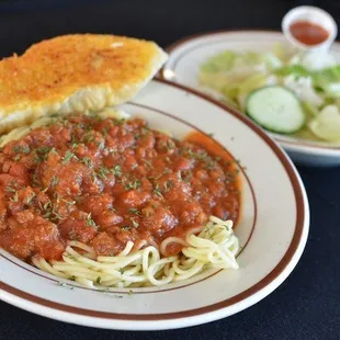 a plate of spaghetti and a side of salad