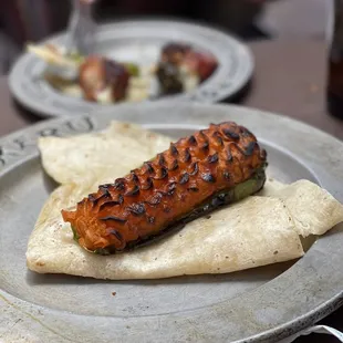 a grilled hot dog on a pita