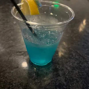 a blue drink with a lemon wedge