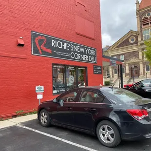 a black car parked in front of a red building