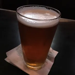 a glass of beer on a napkin