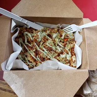 a pizza in a box with a fork and knife