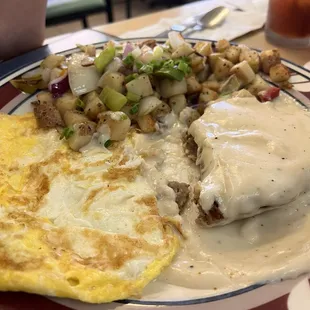 Chicken fried steak and eggs with potatoes.