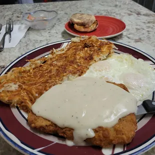 Chicken fried steak and eggs .