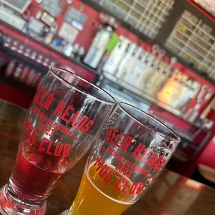 two glasses of beer on a bar