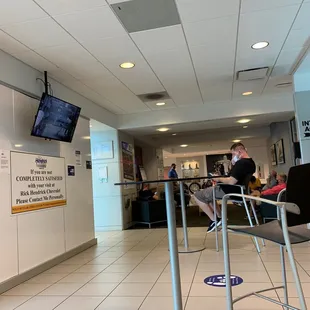 Waiting room at service department... a few non-mask wearers and one improper wearing. Social distancing is so-so.