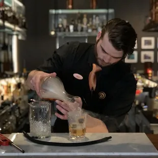 a bartender pouring a drink