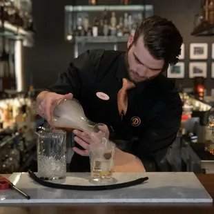 a bartender pouring a drink