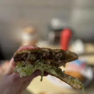 Half-eaten char burger with everything on it