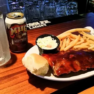 a plate of ribs, fries, coleslaw and a beer