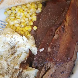 a plate of meat, mashed potatoes and corn