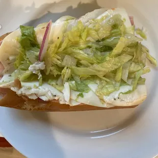 a hot dog with lettuce and onions