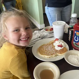 Smiling after the personal touch on her "Minnie Mouse" pancakes